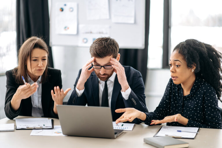 Frustrated business partners sitting around a desk